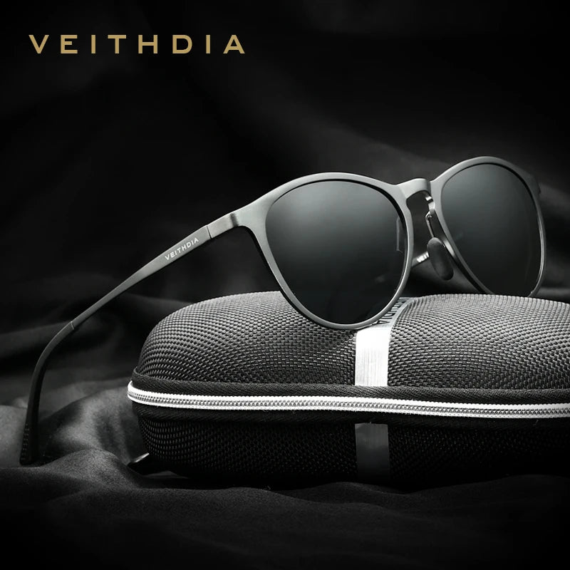Black VEITHDIA sunglasses with round lenses, displayed on a textured zippered case