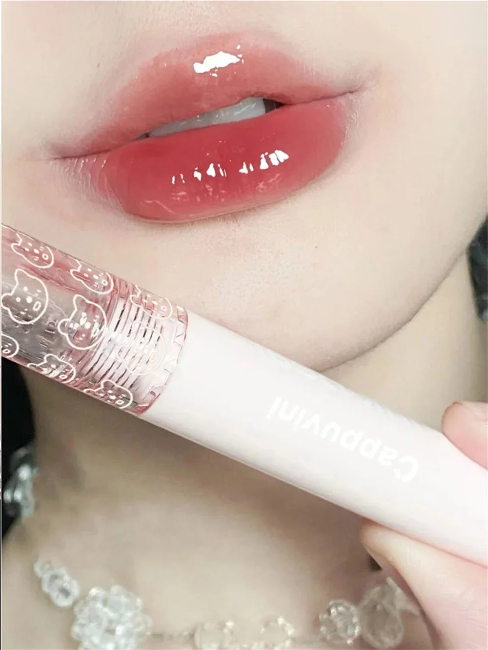 Glossy pink lips with clear lip gloss tube, close-up makeup beauty photo