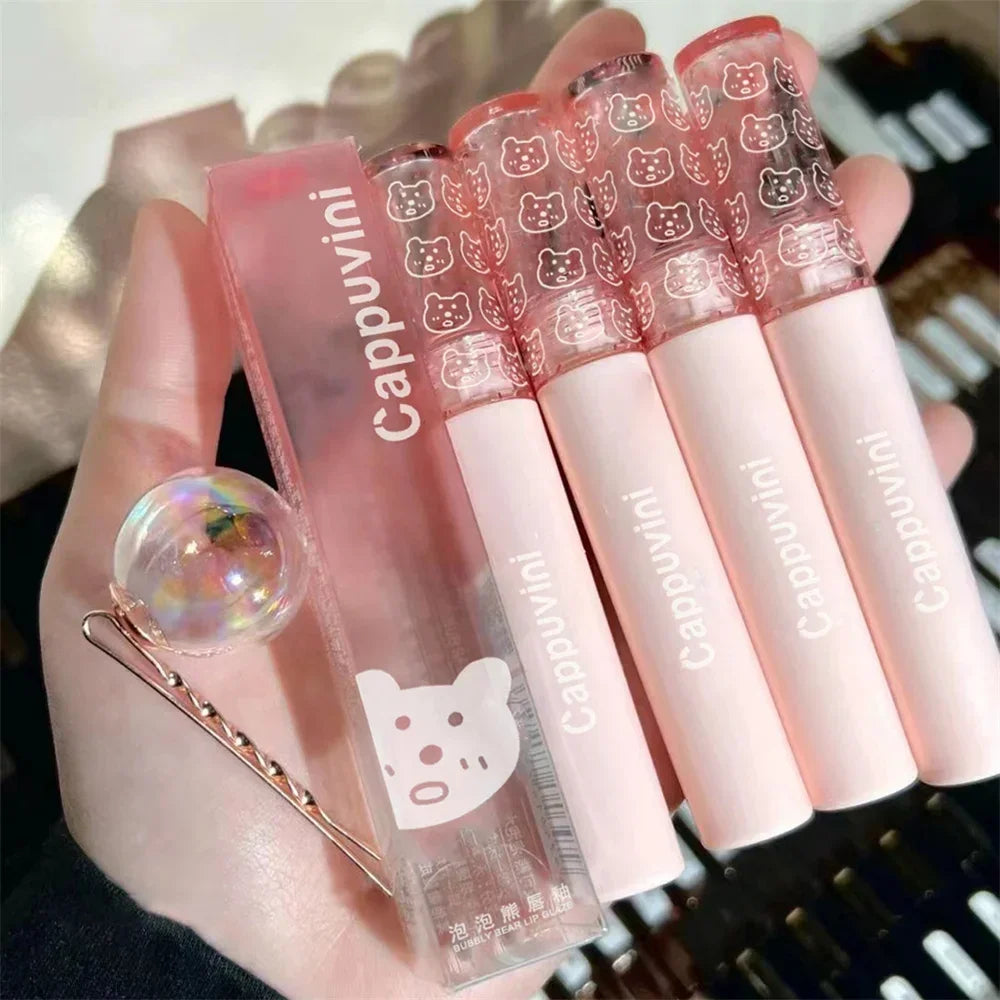 Set of pink Cappuvini bear lip gloss tubes with cute cap designs and a decorative hairpin
