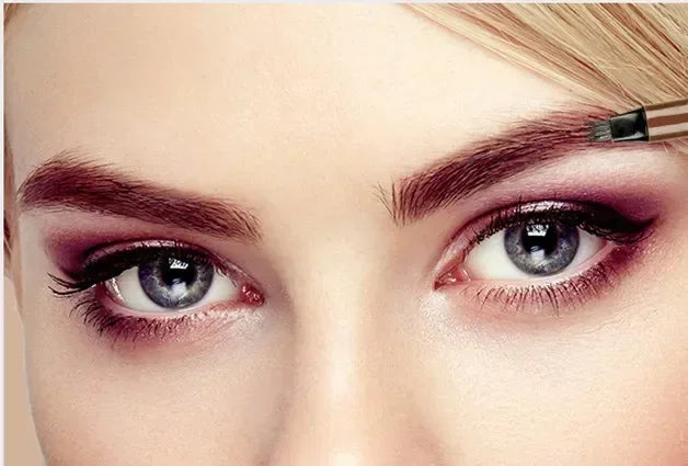 Close-up of woman applying eyebrow makeup with brush, showcasing bold eye makeup