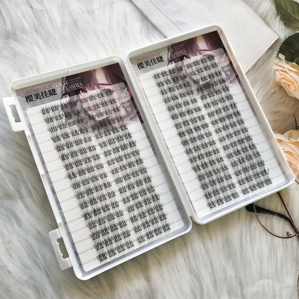 False eyelash clusters in two trays on a white fur background, close-up view
