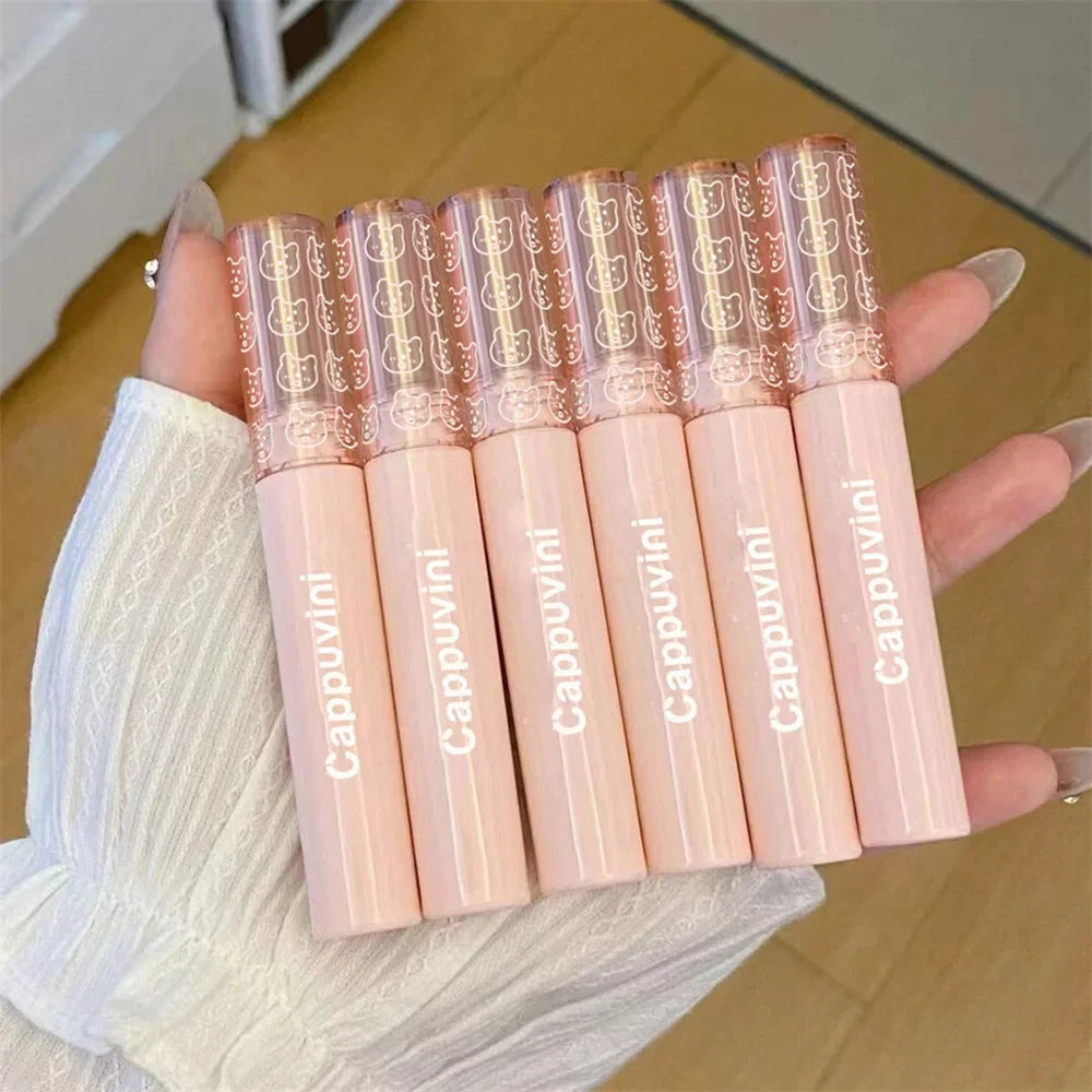 Hand holding six pink Cappuvini lip gloss tubes with cute cat pattern caps