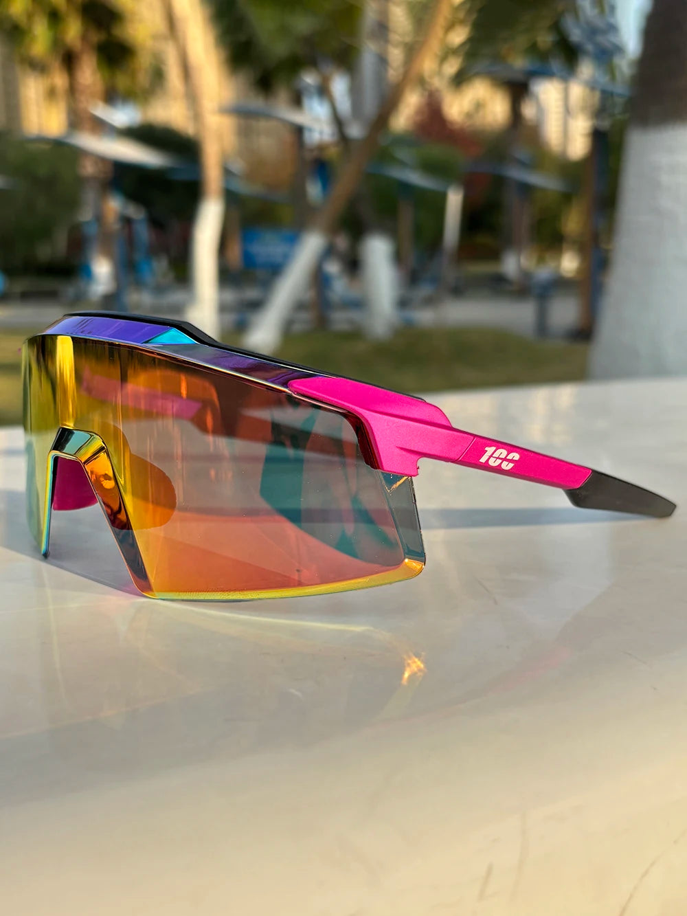 Futuristic sport sunglasses with pink and black frame and rainbow mirrored visor lens