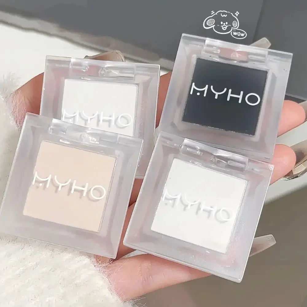 Assorted MYHO single-color eyeshadows in neutral and black shades held in hand