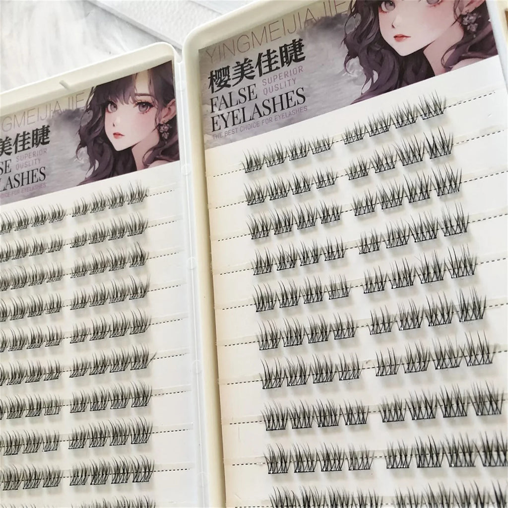 Close-up of two trays of cluster false eyelashes with anime-style illustration on packaging.