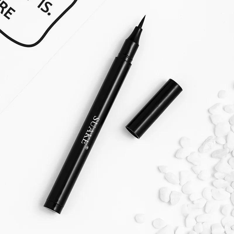 Black liquid eyeliner pen with fine tip and cap, styled on white background with decorative stones