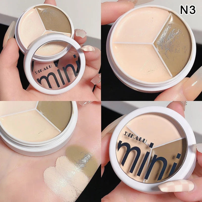 Three-color cream concealer palette with mirror in round compact, swatched on hand, shade N3.
