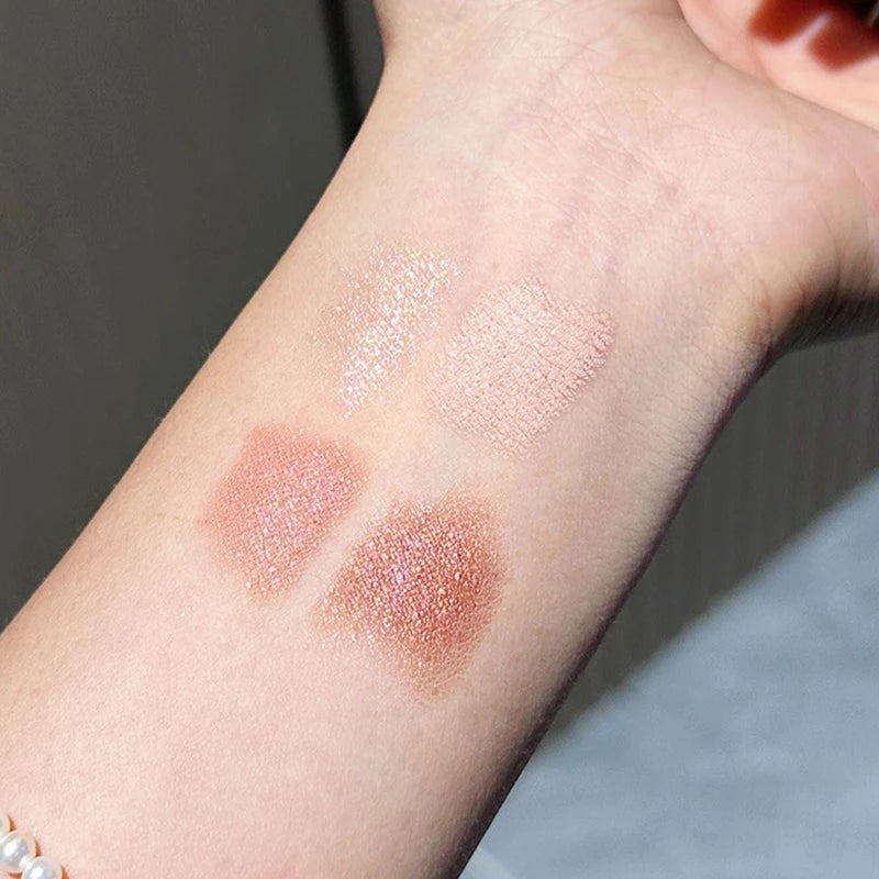 Shimmery nude and bronze eyeshadow swatches on forearm under natural light