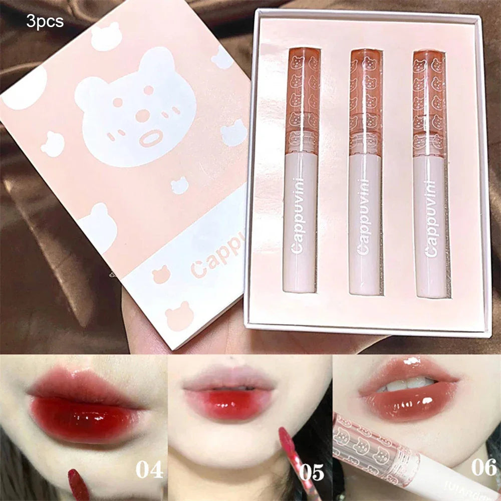 Set of three Cappuvini liquid lip tints in cute bear-themed packaging, swatched on lips in red and pink shades.