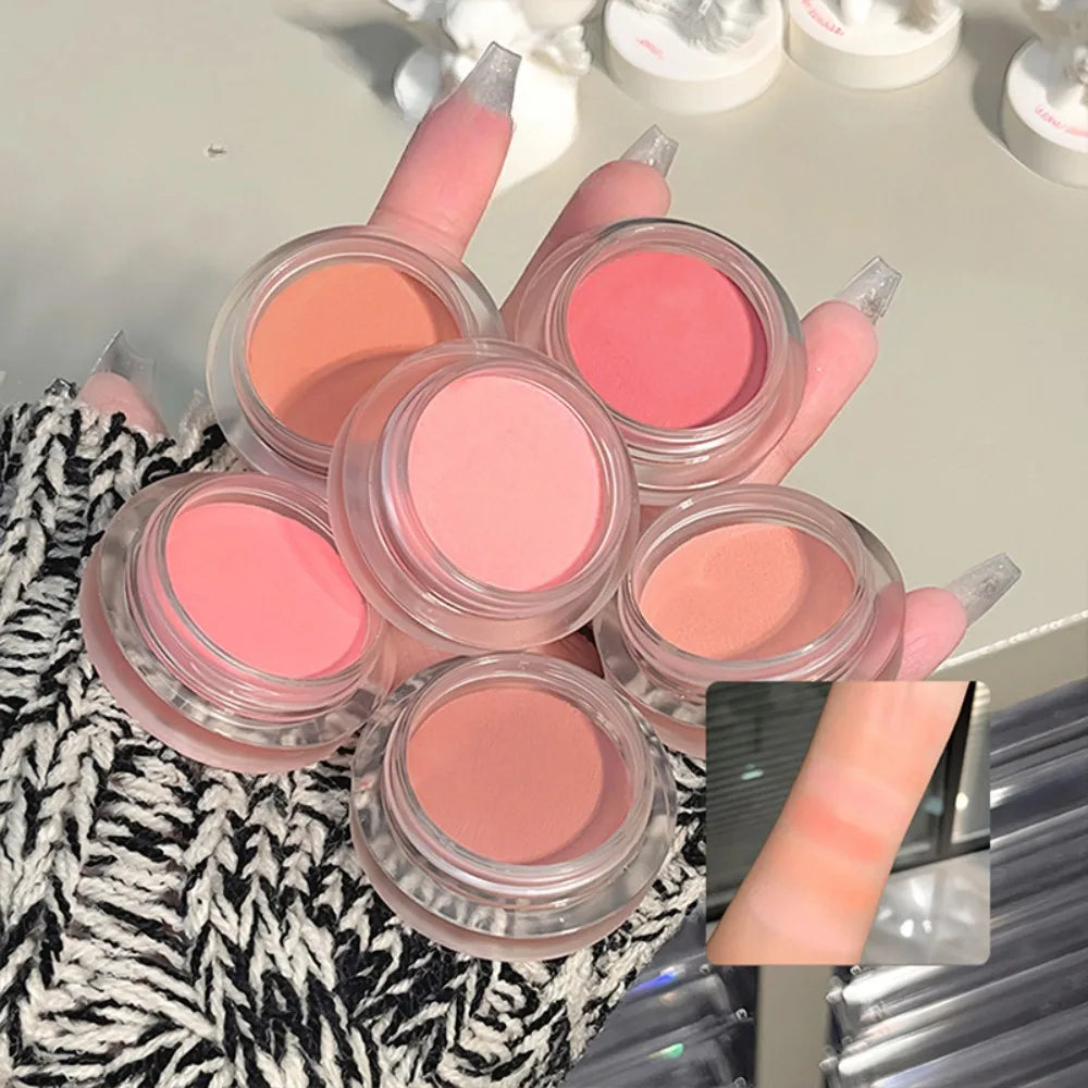 Assorted cream blush makeup palettes in neutral and pink shades displayed on hand.