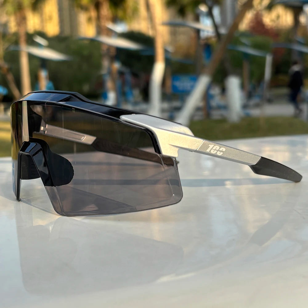 Modern oversized sport sunglasses with black and silver frame, smoked lenses on outdoor table