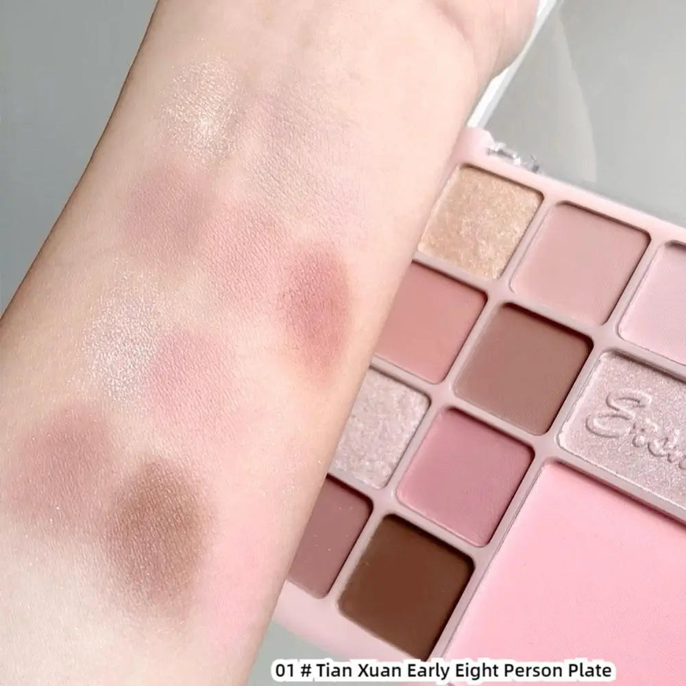 Neutral pink and brown eyeshadow palette with swatches on arm, shimmer and matte finishes.