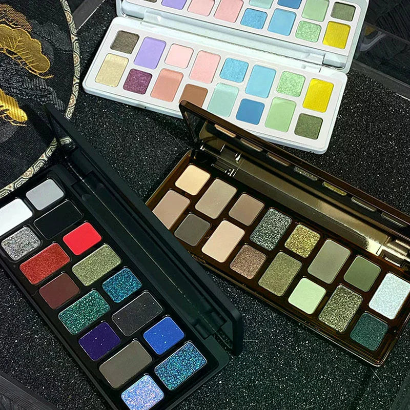 Assorted eyeshadow palettes with vibrant and neutral colors on a black textured surface