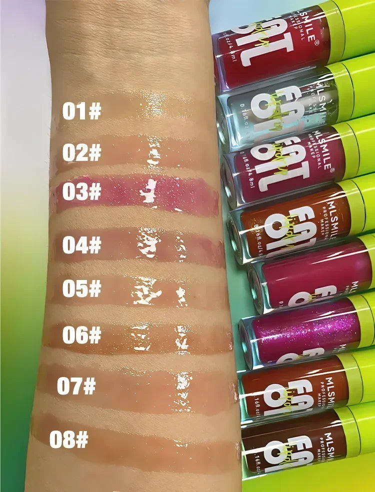 Swatches of eight lip gloss shades on an arm next to colorful lip gloss tubes.