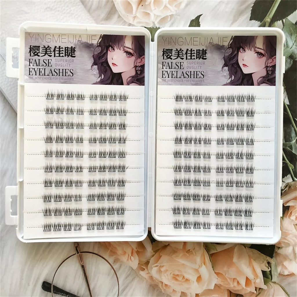 Two trays of cluster false eyelashes on white background with flowers, beauty accessories visible.