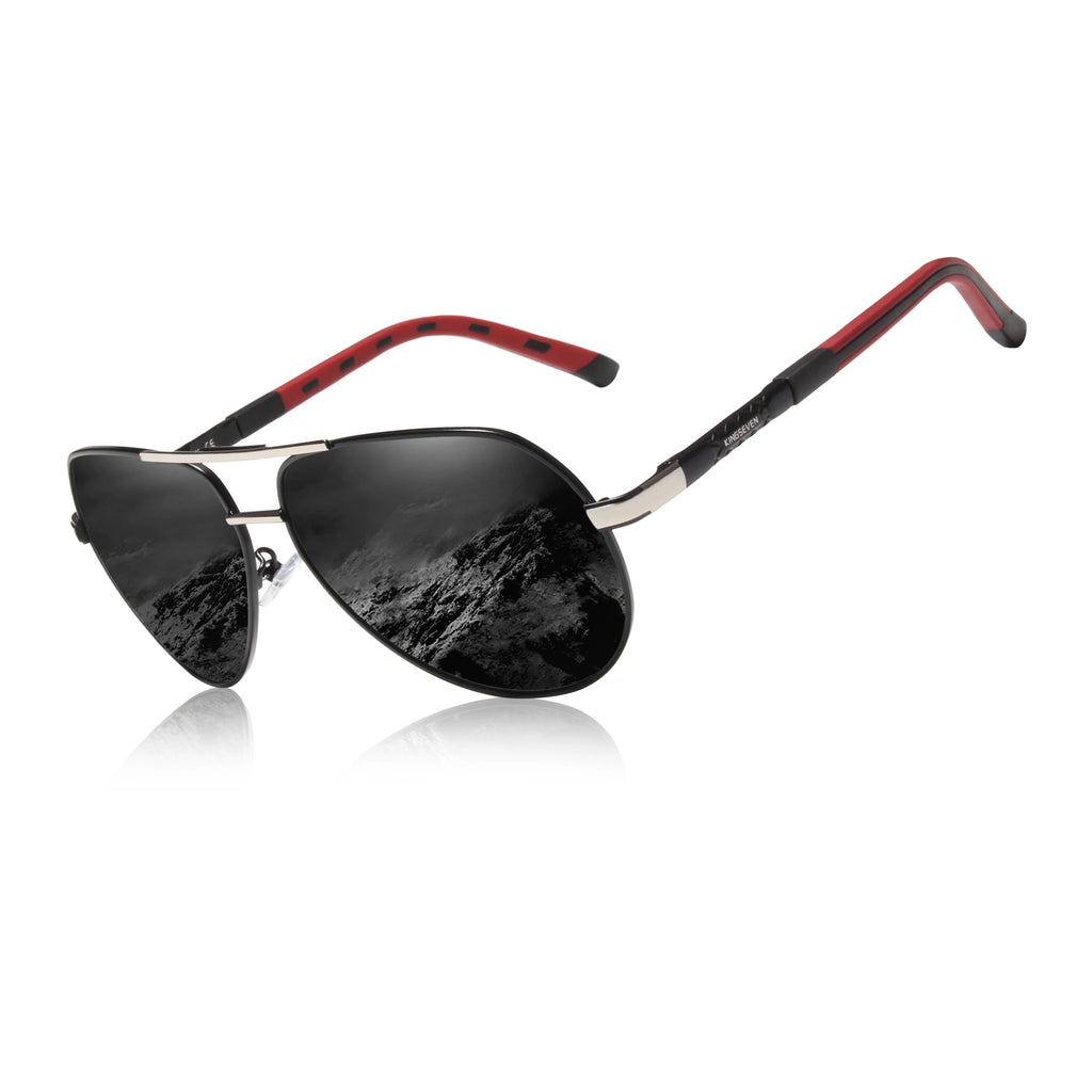 Aviator sunglasses with black lenses, silver frame, and red-black arms, featuring mountain reflection.