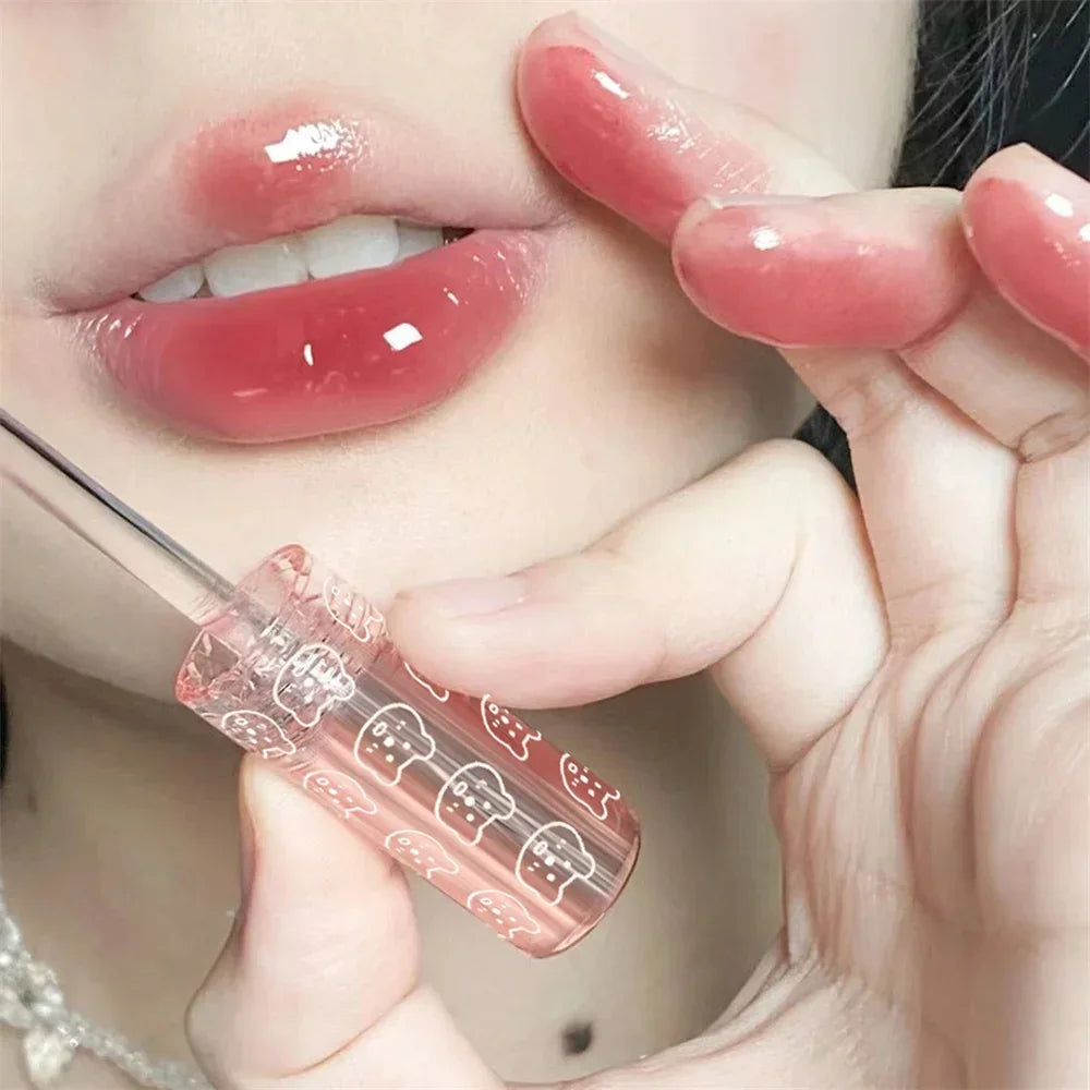 Glossy pink lips with clear lip gloss applicator, close-up beauty makeup photo