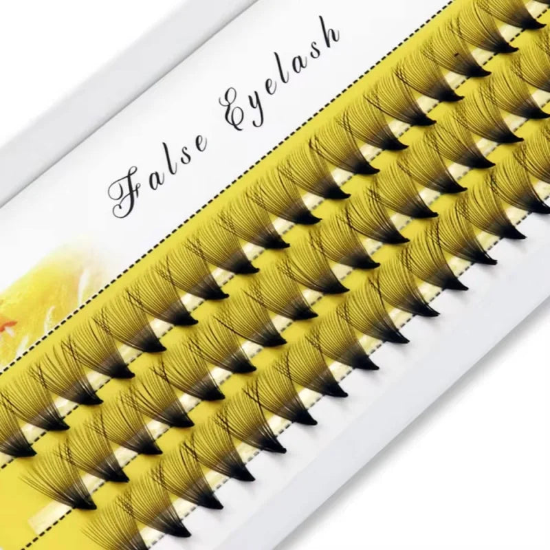 Pack of false eyelash extensions with dramatic volume in a tray, close-up view.